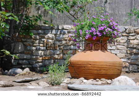 Ancient amphora with flowers in Mediterranean garden