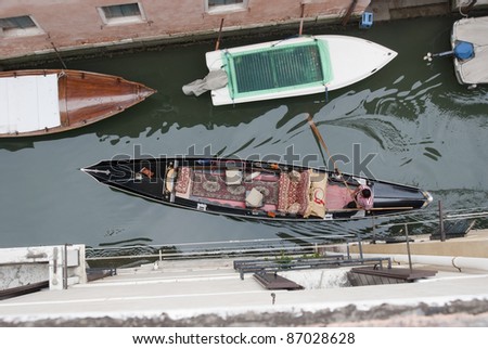Birds eye view on gondola in narrow canal, venice, Italy, Europe. Boats are the daily traffic in this famous city. Watch out for the shape the paddle creates in the water