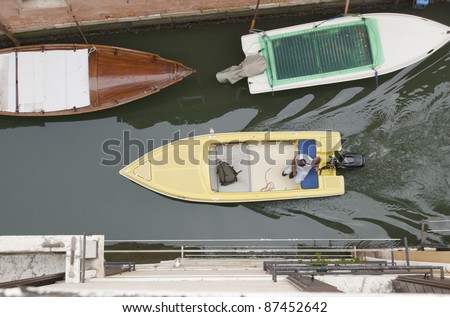 Birds eye view on motorized boat in narrow canal, venice, Italy, Europe. Boats are the daily traffic in this famous city.