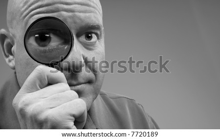 Man Looking Through Magnifying Glass with Big Eye for Humorous Effect