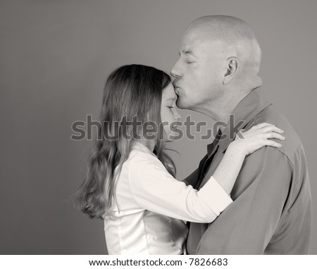 Tender Moment with Father Kissing Daughter on Forehead