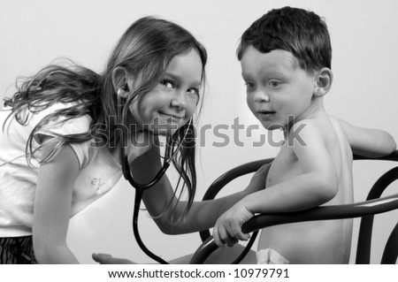 Cute girl using stethoscope to listen to boy\'s heart