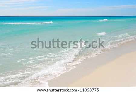 Beautiful gentle waves on pristine beach with turquoise colored water