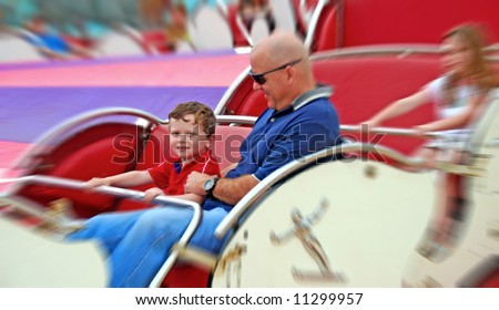 Father and children having fun on spinning amusement park ride