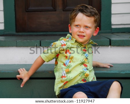 Cute young boy sitting on old front porch