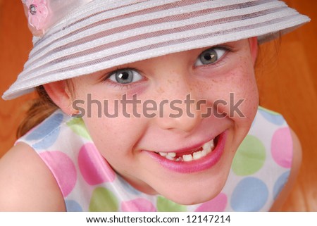 Happy young girl with missing front teeth wearing pretty bonnet