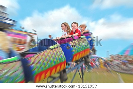 Happy kids on rollercoaster at amusement park