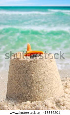 Sandcastle and shells next to pretty ocean