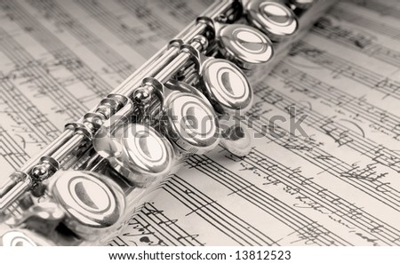 Silver flute instrument resting on handwritten music