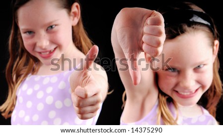 Young girl showing thumbs up and thumbs down
