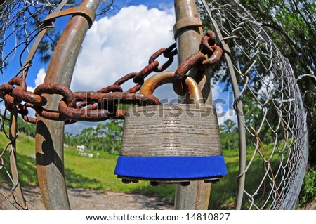 Padlock on fence with heavy chain keeping gate closed