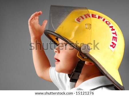 Cute young boy trying on real fireman's helmet