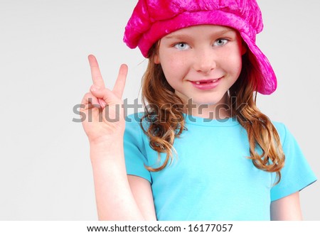 stock photo Young girl in funky cap flashing peace sign with fingers