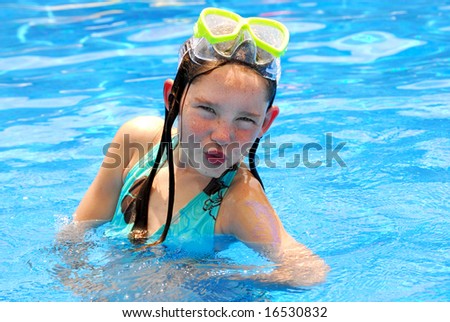 Young girl making silly face while swimming in pool