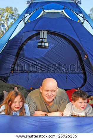 family camping in tent in woods