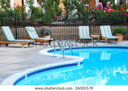 beautiful swimming pool surrounded by chairs and flowers