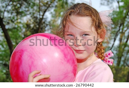 young girl with big bouncy ball outdoors