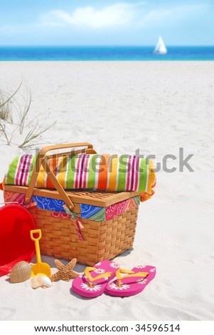 Pretty picnic basket and beach supplies at seashore