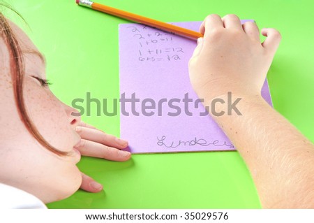 Young child asleep on desk while doing school work