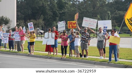 PENSACOLA, FLORIDA - SEPTEMBER 7: Concerned citizens hold signs to protest Healthcare Reform while standing along Davis Highway on September 7, 2009 in Pensacola, Florida.