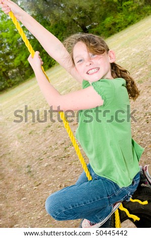 Young girl having fun on tire swing