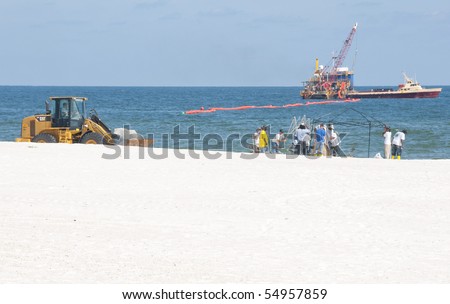 ORANGE BEACH, AL - JUNE 10:  Oil spill workers attempt to clean up oil froma  beach in a tourist resort area on June 10, 2010 in Orange Beach, AL. The beaches are empty except for workers in the height of the tourism season.
