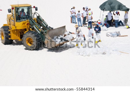 PENSACOLA BEACH - JUNE 23:  BP oil workers and heavy machinery work to remove oil covered sand on June 23, 2010 in Pensacola Beach, FL.