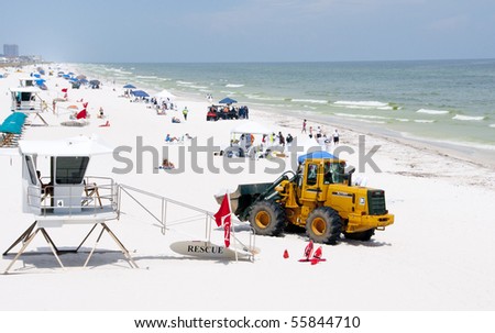 PENSACOLA BEACH - JUNE 23:  BP oil workers and heavy machinery work to clean oil covered sand on June 23, 2010 in Pensacola Beach, FL.