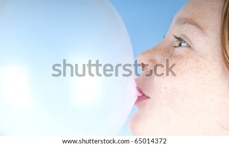 freckle faced girl blowing bubble with gum