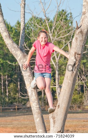 happy girl climbing park tree