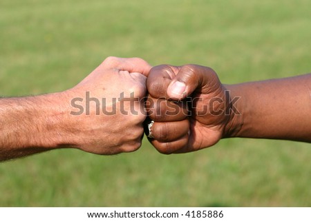 Black and white man touching fists to show unity