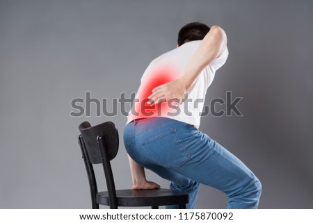 Back pain, kidney inflammation, man suffering from backache, painful area highlighted in red