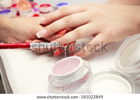 Artificial nails in a beauty salon. Hands close-up. The process of nails.
