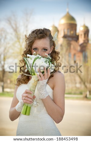 Beautiful bride in a white dress with a bouquet of calla lilies