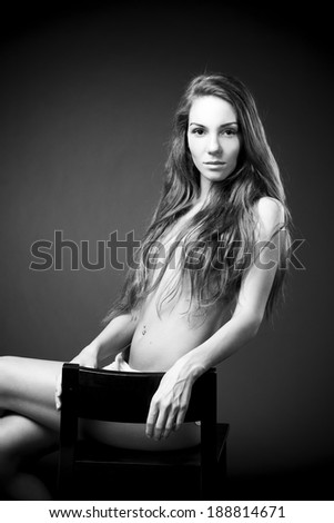 Young naked girl in studio. Black and white photography