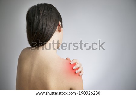 Hands on a woman\'s shoulder. Pain in the muscles.