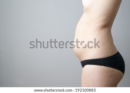 Young woman\'s body on gray background. Weight loss, diet
