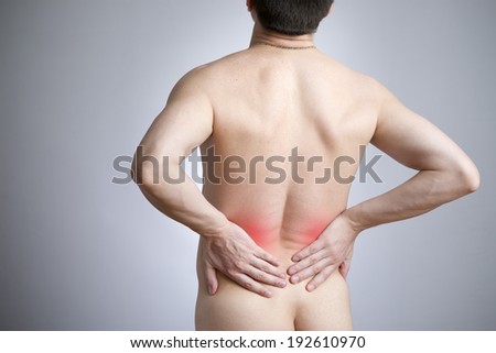 Pain in a back of the man on gray background. Red dot