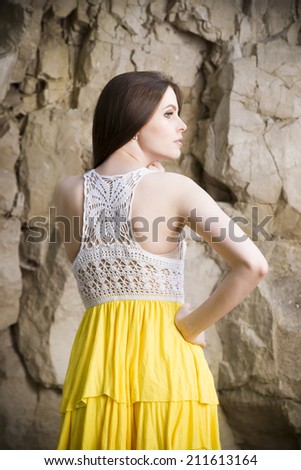 Portrait of a beautiful young woman on nature. Girl in a  knitted dress in the rocks.