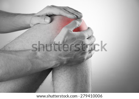 Knee pain in men on gray background