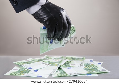 Concept - corruption, theft. Hand in glove leathern designed to steal money.