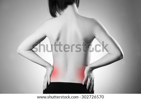 Woman with backache. Pain in the human body on a gray background