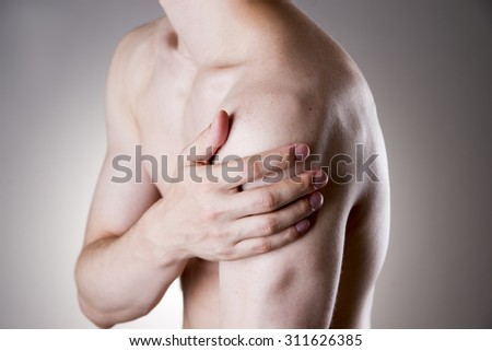 Man with pain in shoulder. Pain in the human body on a gray background