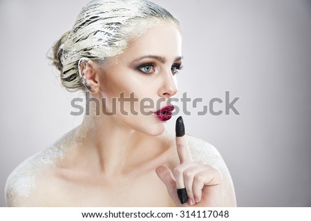 Portrait of a beautiful woman with creative makeup. Spa. Skin care and hair care. Hair mask of clay