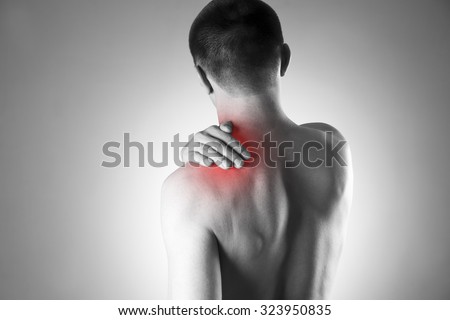 Man with pain in shoulder. Pain in the human body. Black and white photo with red dot