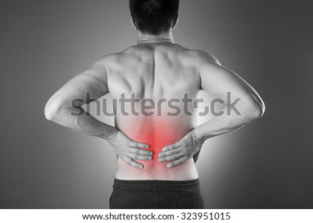 Kidney pain. Man with backache. Pain in the man\'s body. Black and white photo with red dot