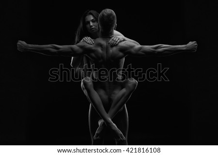 Nude sexy couple. Art photo of young adult man and woman. High contrast black and white muscular naked body on black background