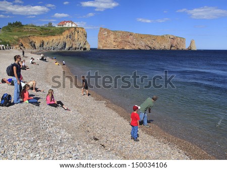 PERCE CANADA-JULY 22: People enjoy the beach near Perce Rock, a huge sheer rock formation in the Gulf of Saint Lawrence, Gaspe Peninsula in Quebec, Canada, off Perce Bay on July 22 2013.