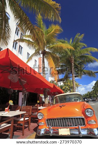 MIAMI BEACH, FL - DEC 30: Old car and restaurants on Ocean Drive, the major thoroughfare in the South Beach on Dec 30, 2014 in Miami Beach, FL, USA