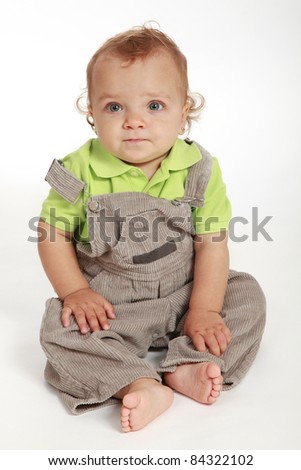 Cute baby girl wearing a green T-shirt and gray pants